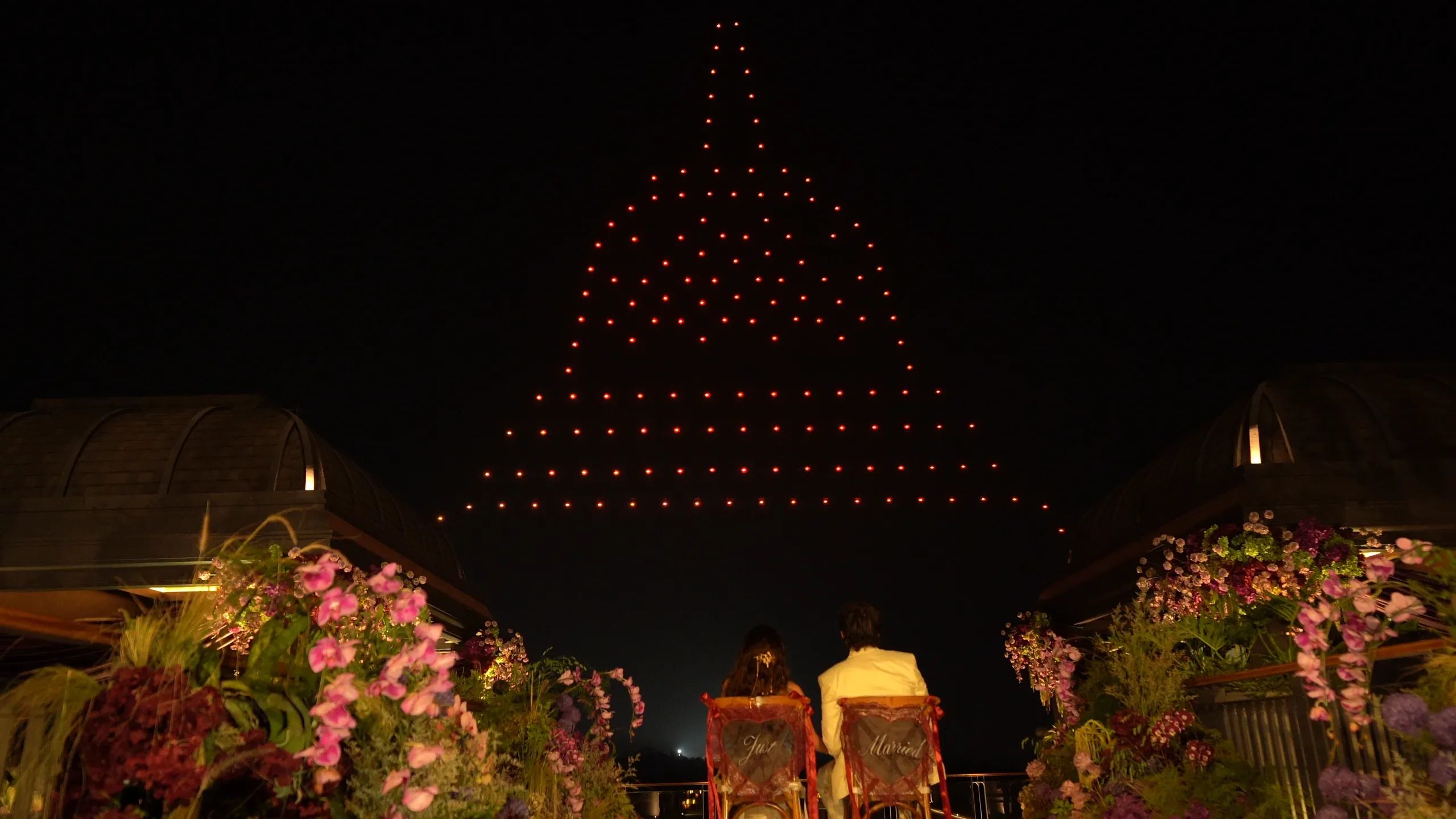 Rahmani dan Glen menyaksikan cahaya drone merah berbentuk sebagian Candi Borobudur.
